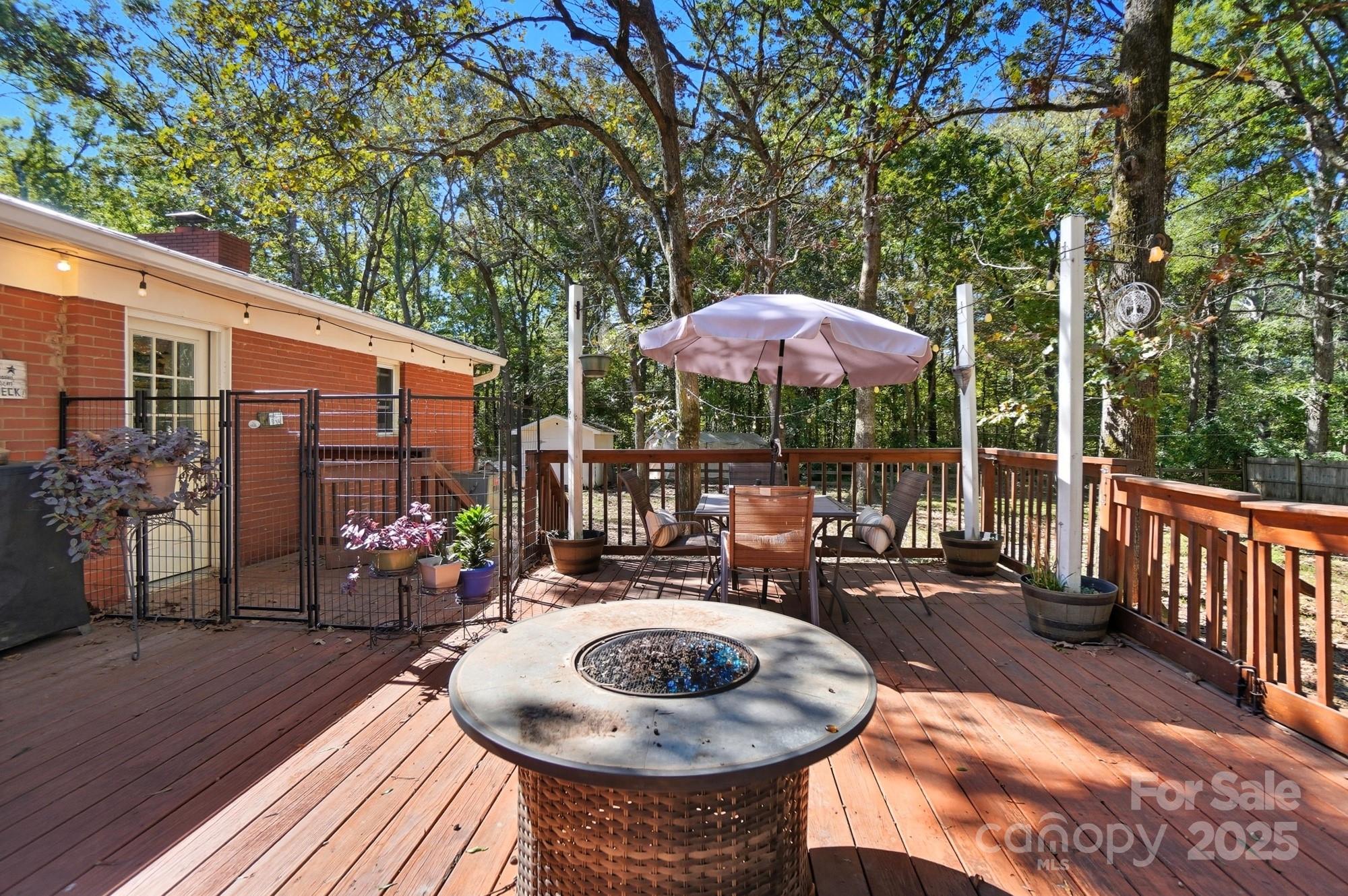 109 Carter Road Monroe, NC 28110 - Photo 41 of 48 a view of a patio with couches table and chairs under an umbrella with wooden floor