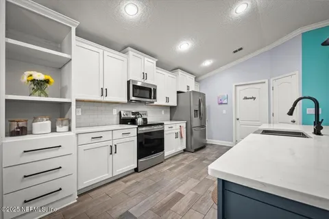 a kitchen with a table chairs refrigerator and microwave