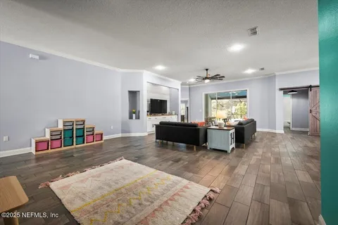 a living room with furniture and a wooden floor