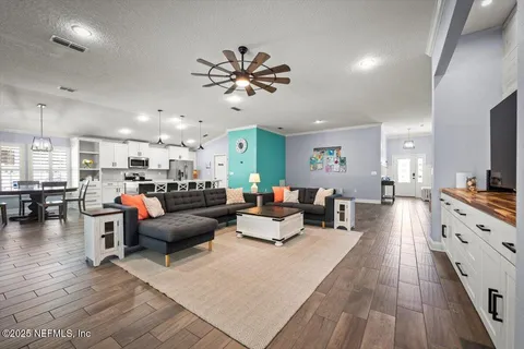 a living room with furniture and a chandelier