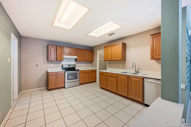 a large kitchen with stainless steel appliances granite countertop a sink and cabinets