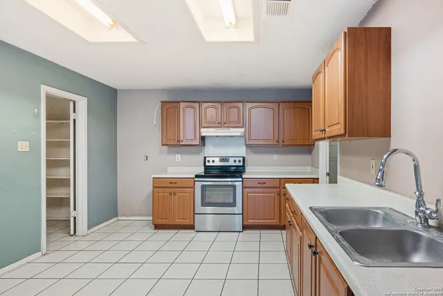 a kitchen with a stove sink and cabinets