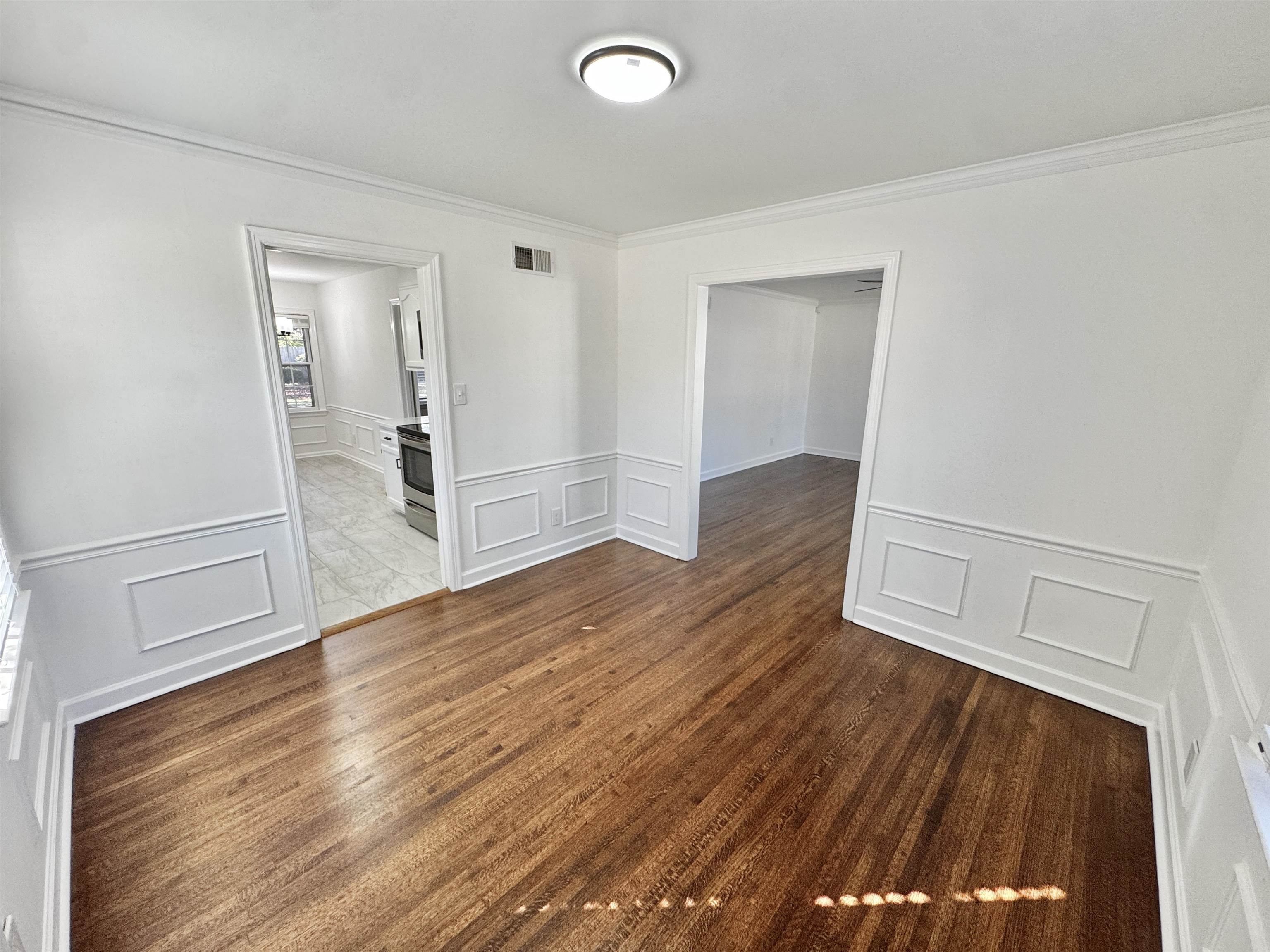 4417 Fair Meadow Road Memphis, TN 38117 - Photo 17 of 38 Unfurnished room with a decorative wall, a wainscoted wall, dark wood finished floors, and crown molding