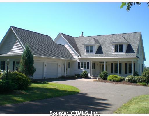 a front view of a house with a yard and potted plants