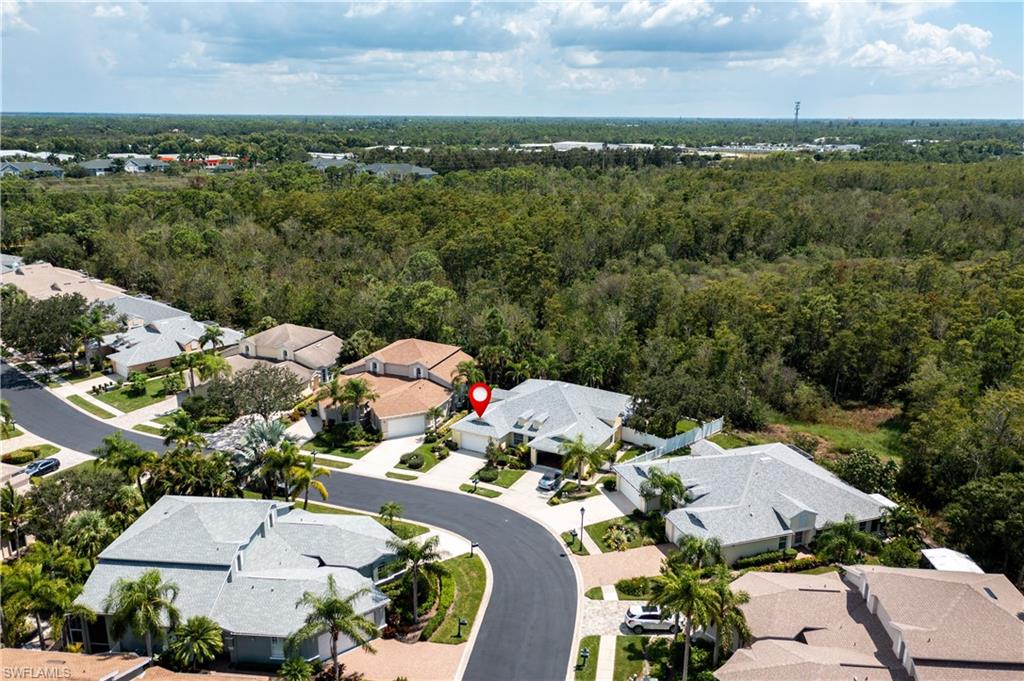 15079 Sterling Oaks Drive Naples, FL 34110 - Photo 22 of 29 an aerial view of a house with lots of trees