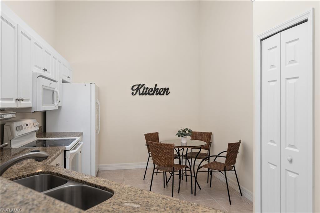 15079 Sterling Oaks Drive Naples, FL 34110 - Photo 7 of 29 a view of a kitchen with a table and chairs