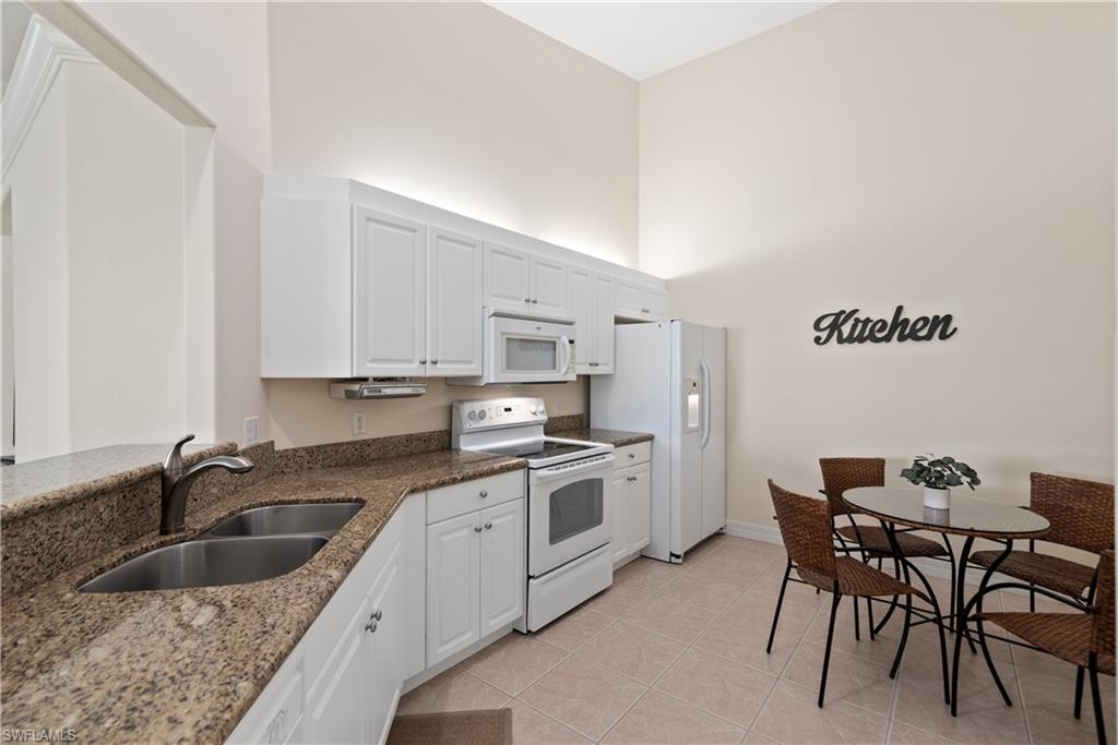15079 Sterling Oaks Drive Naples, FL 34110 - Photo 8 of 29 a kitchen that has a sink and a stove in it