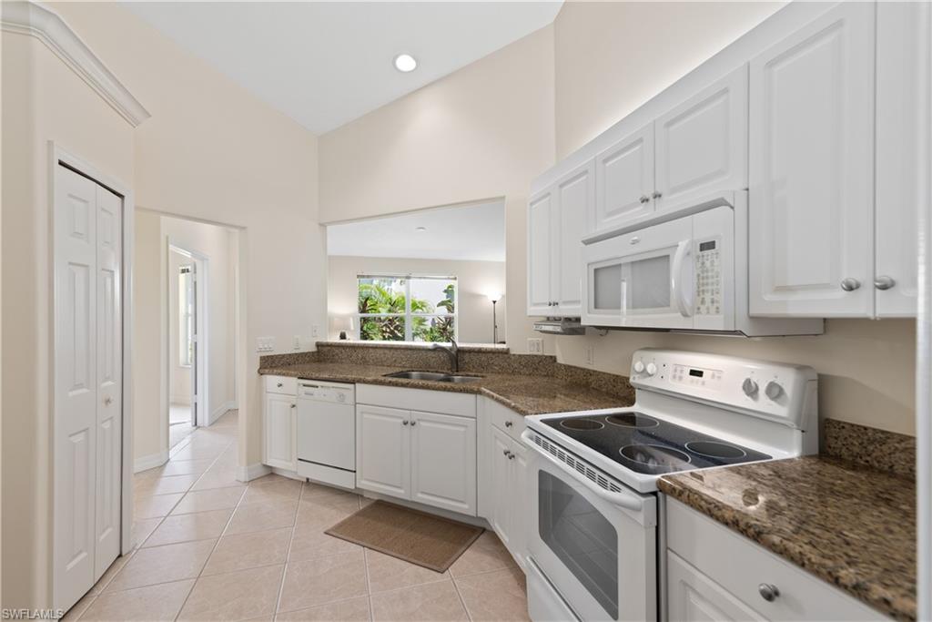15079 Sterling Oaks Drive Naples, FL 34110 - Photo 9 of 29 a kitchen with granite countertop a sink stove and cabinets