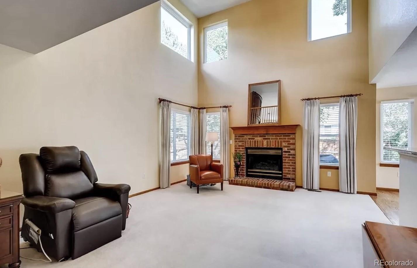 9832 South Spring Hill Place Highlands Ranch, CO 80129 - Photo 12 of 25 a living room with furniture and a fireplace