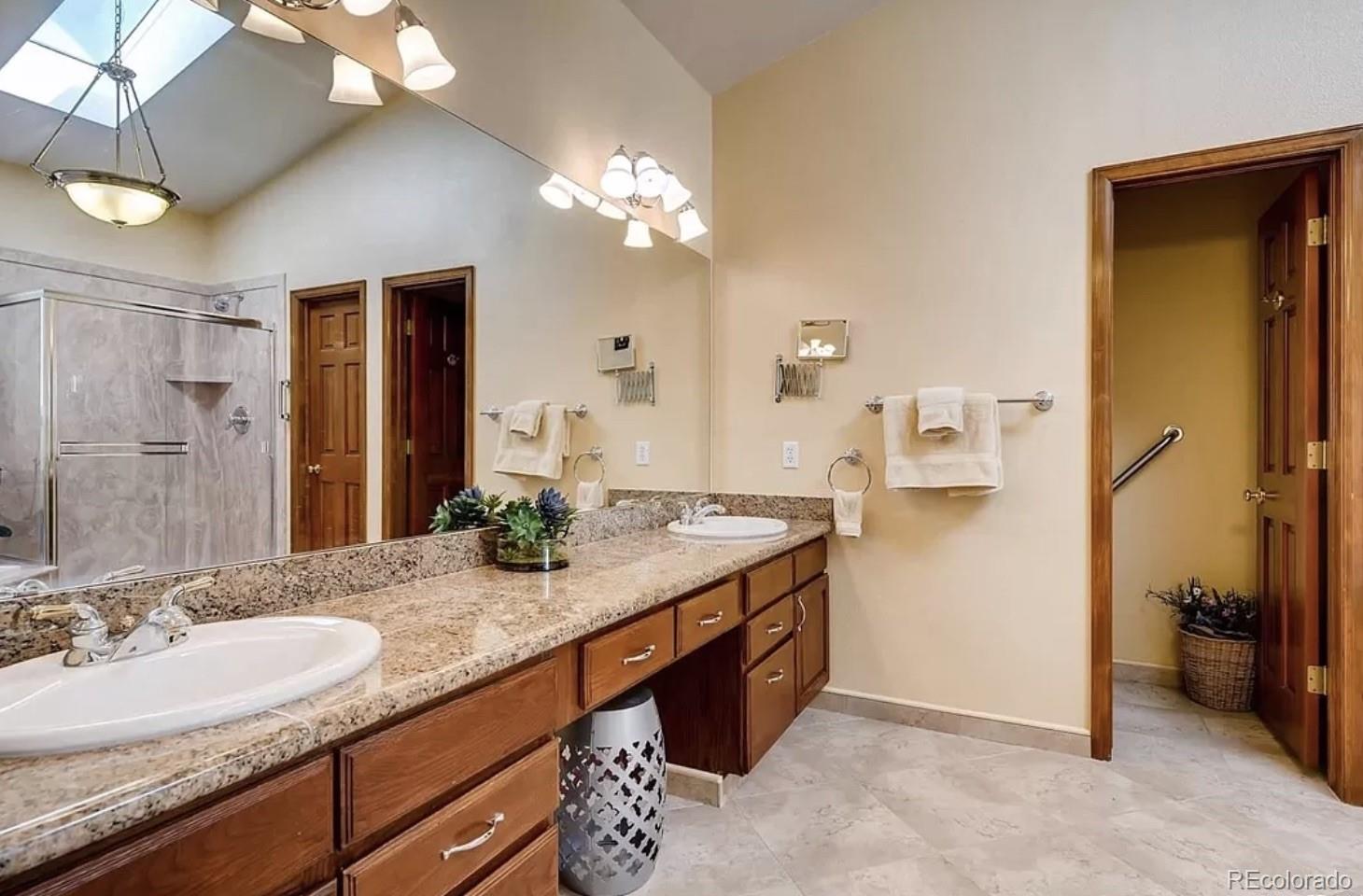 9832 South Spring Hill Place Highlands Ranch, CO 80129 - Photo 15 of 25 a bathroom with a granite countertop sink and a mirror