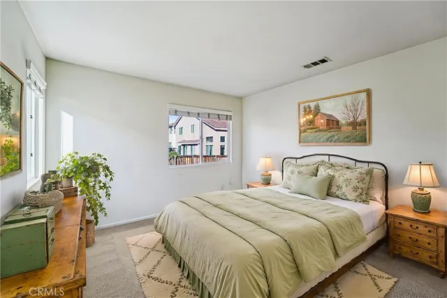 a bedroom with a bed and a potted plant