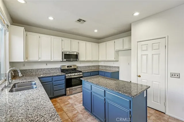 a kitchen with granite countertop stainless steel appliances and white cabinets