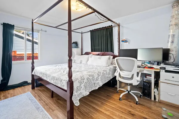 a bedroom with a bed and a dresser next to a window