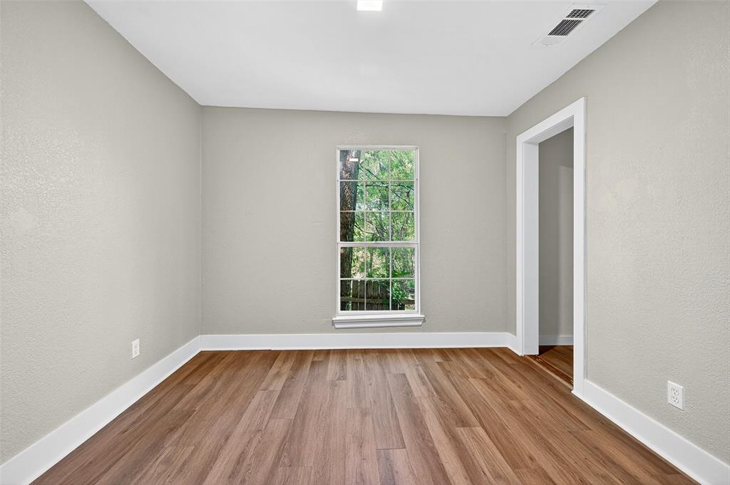 205 West Bond Street Denison, TX 75020 - Photo 12 of 23 Bedroom 3 featuring a textured wall and wood finished floors