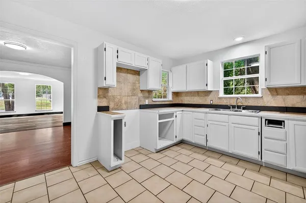 a kitchen with a sink window and cabinets