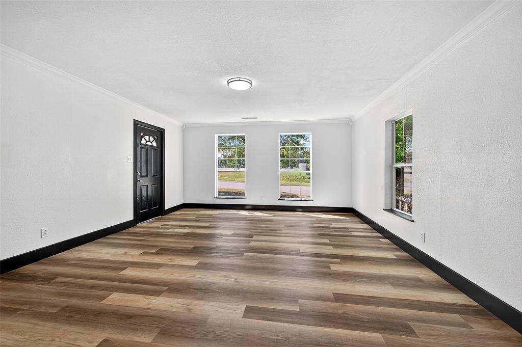 205 West Bond Street Denison, TX 75020 - Photo 6 of 23 Living room with crown molding, wood finished floors, plenty of natural light, and a textured wall
