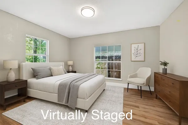 a spacious bedroom with a bed and wooden floor