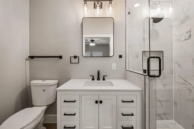a bathroom with a sink vanity mirror and toilet