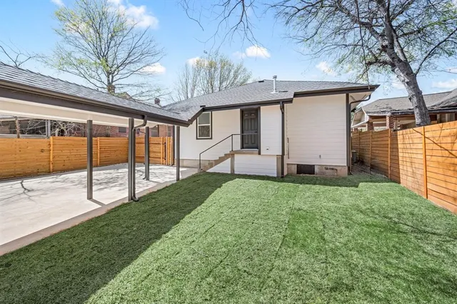 a view of a house with backyard and a tree