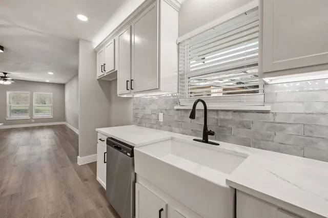 a kitchen with a sink cabinets and wooden floor
