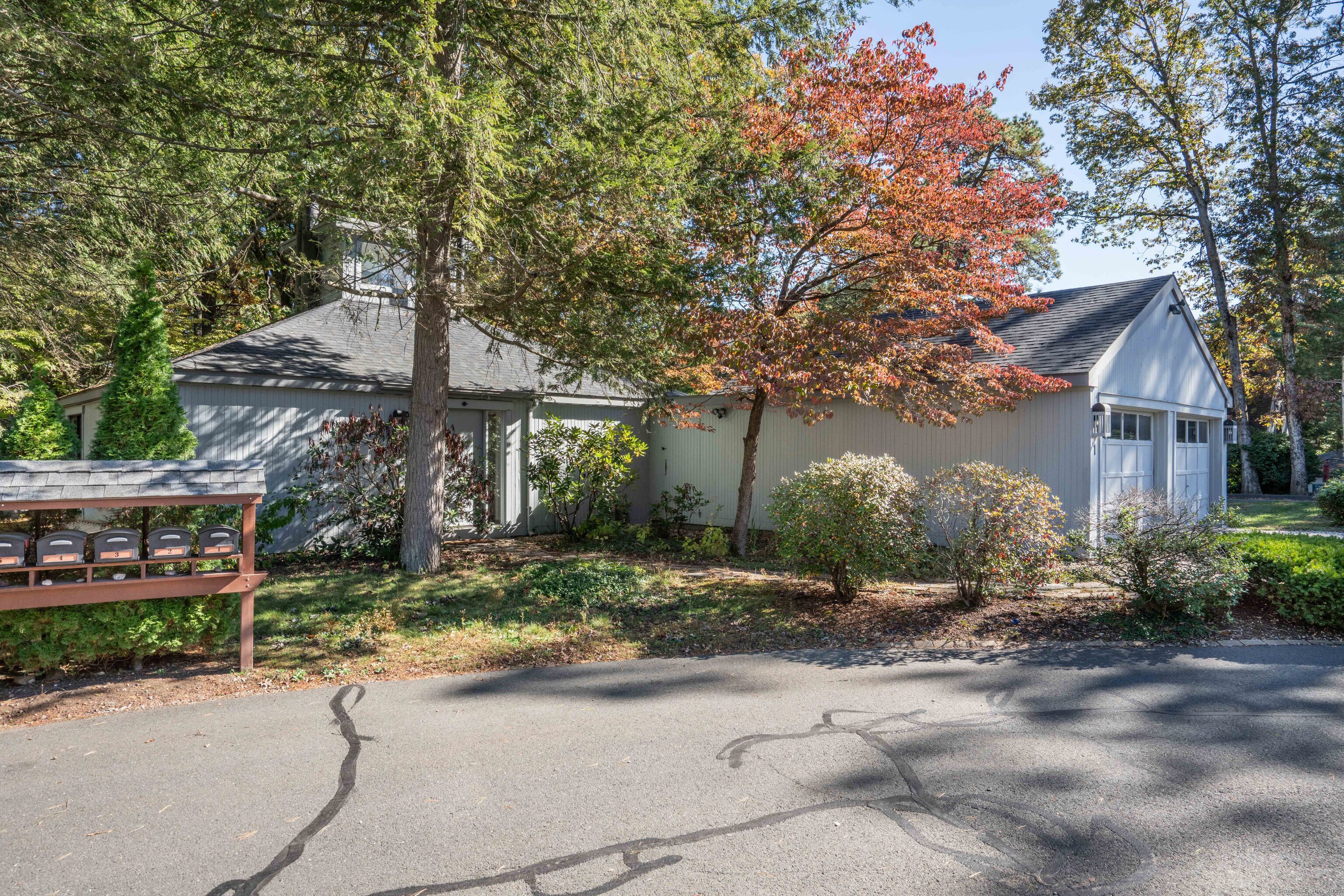 a front view of a house with a yard and tree s