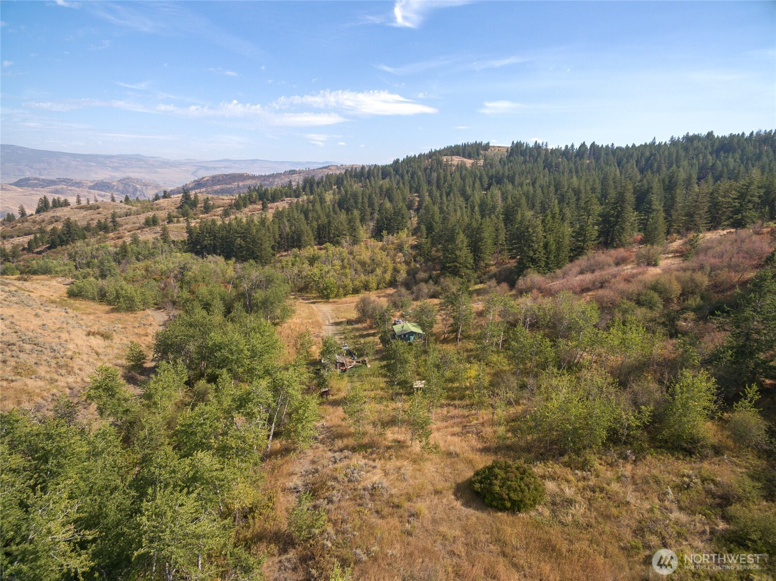 653 B Ellemeham Mountain Road Oroville, WA 98844 - Photo 22 of 33 a view of a dry yard with mountains in the background