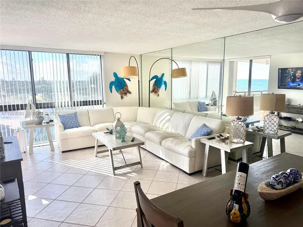 a living room with furniture and a large window with garden view