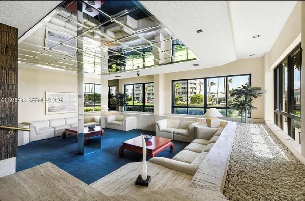 a living room with furniture large window and wooden floor