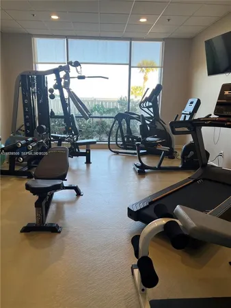 a room with gym equipment and a flat screen tv