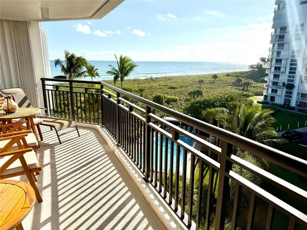 a view of a balcony with wooden floor and fence