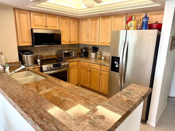 a kitchen with stainless steel appliances granite countertop a refrigerator stove top oven a sink and dishwasher