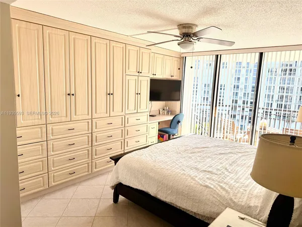 a bedroom with a bed a window and a flat screen television