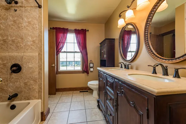 a bathroom with a granite countertop toilet a sink and a mirror