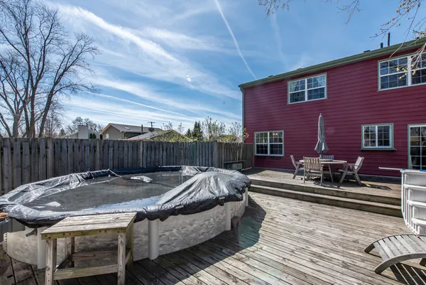 a view of backyard with seating space and wooden fence