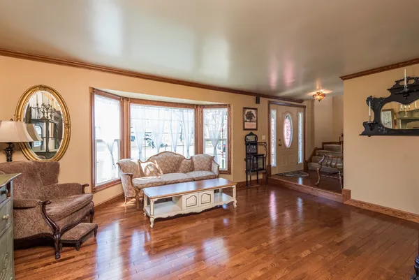 a living room with furniture large window and wooden floor