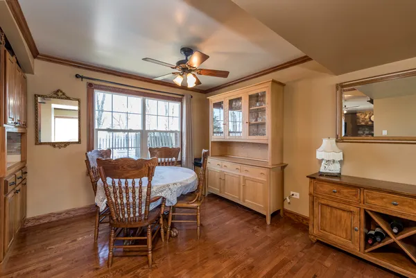 a dining room with furniture a chandelier and wooden floor