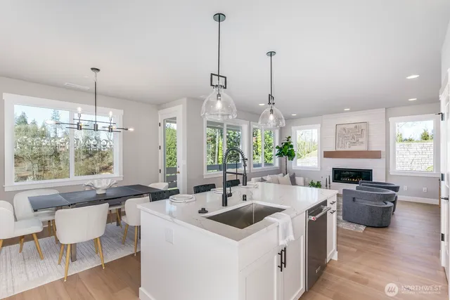 a kitchen that has a stove a sink a counter space and a view of living room