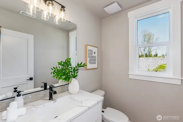 a bathroom with a sink a toilet and a mirror