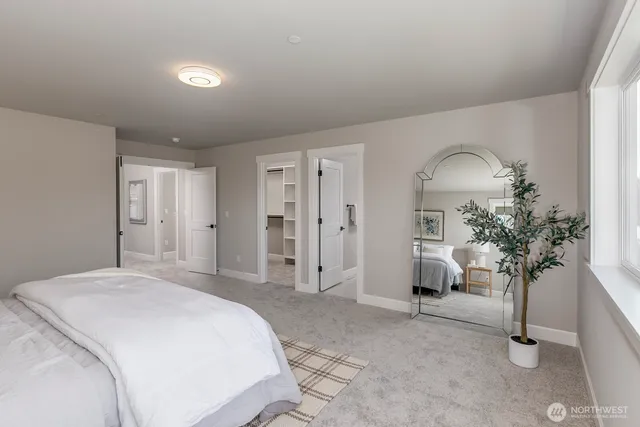 a spacious bedroom with a bed and a potted plant