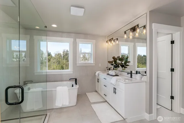 a bathroom with a double vanity sink bathtub and mirror