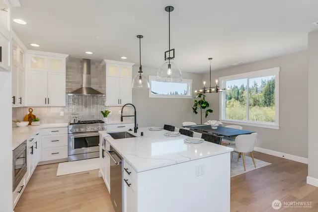 a kitchen with a stove a sink a center island and windows