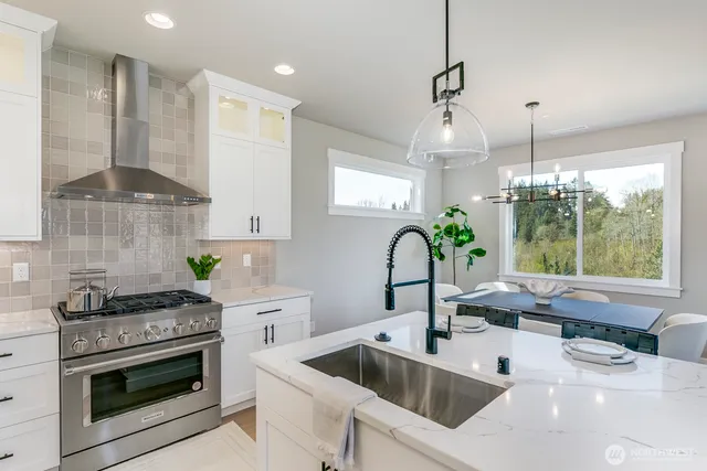 a kitchen with stainless steel appliances a sink a stove a counter space and a window