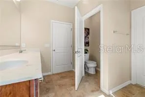 a bathroom with a granite countertop toilet a sink and a mirror