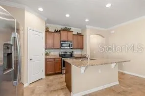 a kitchen with stainless steel appliances granite countertop a stove a refrigerator and a sink