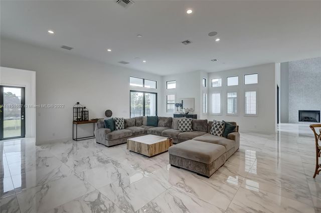 a large kitchen with kitchen island a large counter top stainless steel appliances and cabinets