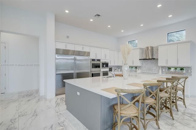 a large white kitchen with a large window