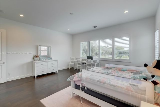 a view of staircase with lots of frames on wall and wooden floor