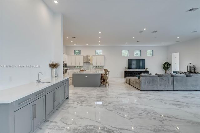 a living room with furniture and kitchen view