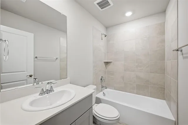 a bathroom with a bathtub shower sink vanity mirror and toilet