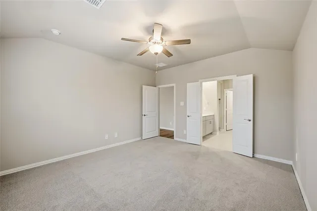 an empty room with closet and a ceiling fan